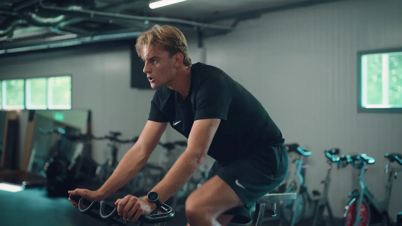 Een rijder vol inspanning op de fiets in de krachtruimte